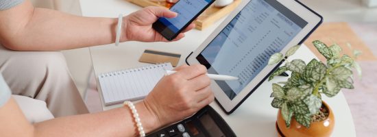 Hands of senior woman checking investment account via application on tablet computer and buying new stocks and receiving dividends